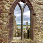 Irland Roadtrip: Blick durch eines der erhaltenen Fenster von Clonmacnoise auf die Ruinen und den Shannon River