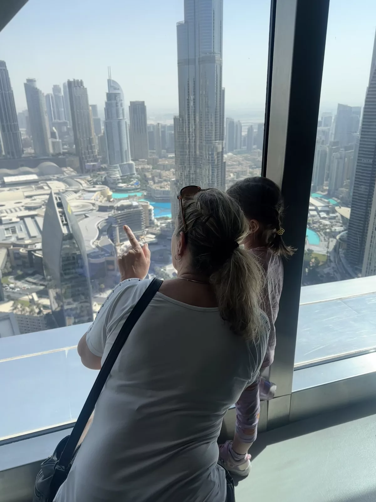 Oma und Enkelin schauen sich die Hochhäuser in Dubai von oben an